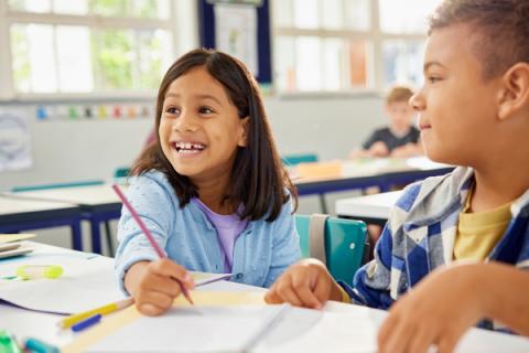 Kid smiling in a classroom setting