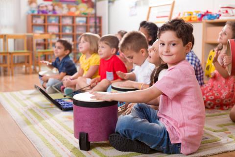 Child plays a drum in music class at school